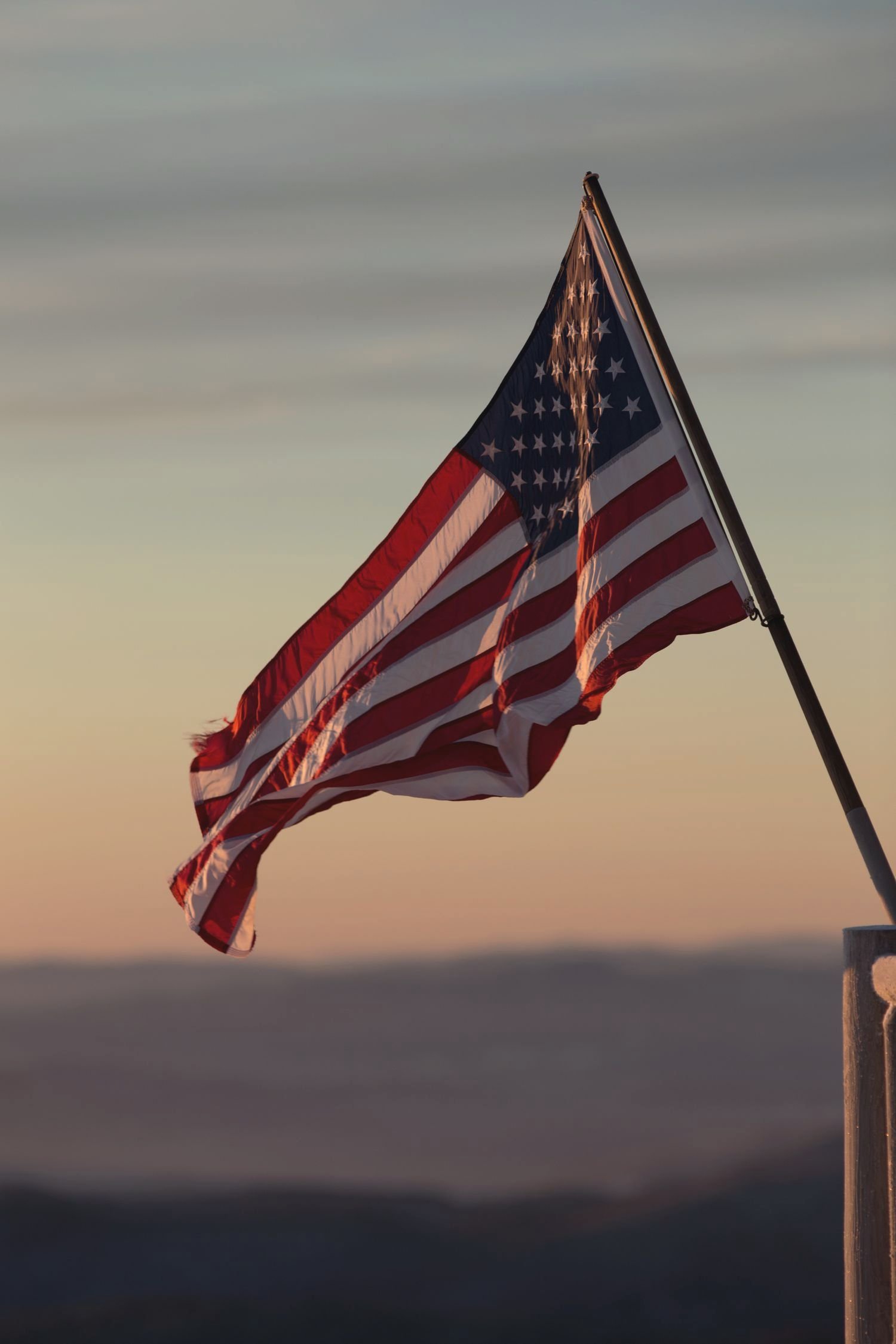 The American flag flying against an evening sky
